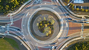 Aerial view of road roundabout intersection with fast moving heavy traffic. Timelapse of urban circular transportation