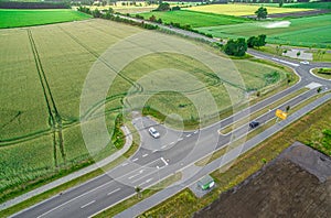 Aerial view of a road with signs and guidelines for traffic between a new development area for an industrial estate and an arable