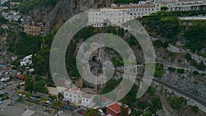 Aerial view of road with tunnel in high rock above sea coast in attractive travel destination. Amalfi, Italy