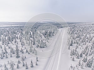 Aerial view of the road in the winter snow forest in Finland