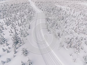 Aerial view of the road in the winter snow forest in Finland