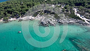 Aerial view of rocky beach with turquoise water in Halkidiki Kavourotripes, Greece, circular movement by drone, 4K resolution