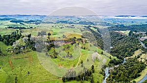 Aerial view on a rocky cliff with forest and farmland on the background. Taranaki region, New Zealand