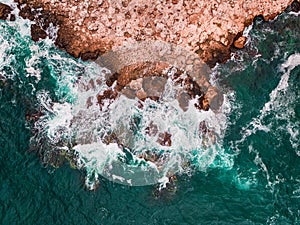 Aerial view of rocky coastline with crashing waves