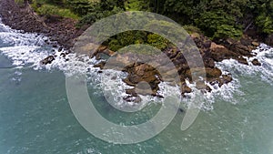Aerial view of a rocky and green beach shore.