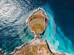 Aerial view of rocky island with rocks and blue ocean
