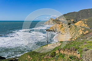 Aerial view of the rocky Pacific Ocean shoreline and scenic highway near Devil`s Slide, California