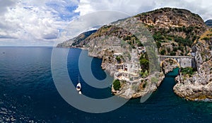 Aerial view of the rocky seashore of southern Italy. Boat. Incredible beauty panorama of mountains and sea. Travel and tourism.