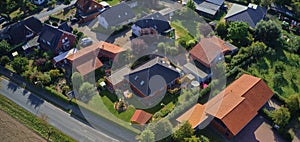 Aerial view of the roofs of a single-family house settlement on the edge of the country road of a German suburb