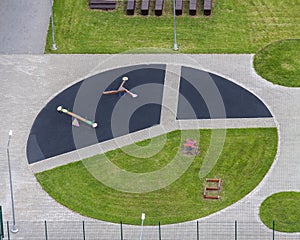 Aerial view round children's fitness playground with sport equipments green grass background.