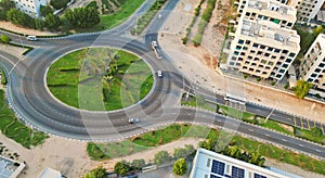 Aerial view of a roundabout in a residential area near a town, surrounded by a mixture of buildings