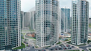 Aerial view of a row of high-rise new buildings in a new residential area against the background of the city panorama