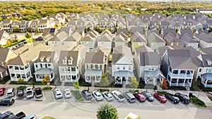 Aerial view row of upscale cottage style homes with parked cars on street near historic Old Town Coppell, Texas, USA