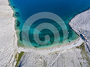 Aerial view of Rucica beach on Pag island, Metajna, Croatia. Seabed and beach seen from above, bathers, relaxation and holidays