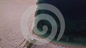 Aerial view of Rucica beach on Pag island, Metajna, Croatia. Seabed and beach seen from above, bathers, relaxation and summer holi