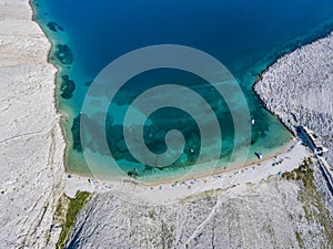 Aerial view of Rucica beach on Pag island, Metajna, Croatia. Seabed and beach seen from above, bathers, relaxation and holidays photo