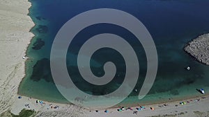Aerial view of Rucica beach on Pag island, Metajna, Croatia. Seabed and beach seen from above, bathers, summer