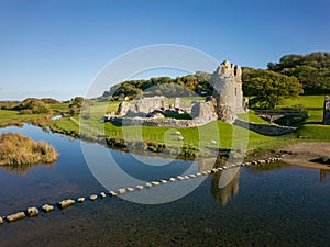 Aerial view of a ruined Norman era castle in a rural area Ogmore Castle, Wales