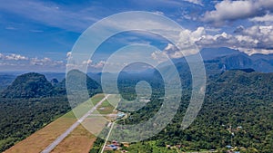 Aerial view of runway in secluded airport near tropical forest and mountains near Gunung Mulu national park. Borneo. Sarawak.