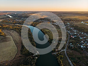 Aerial view of rural countryside, beautiful autumn nature landscape panorama from above with big river and farm fields