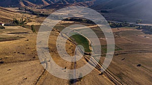 Is an aerial view of a rural farm, featuring lush green fields
