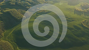 aerial view of the rural landscape with green fields and forests at sunrise.