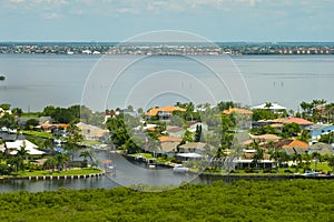 Aerial view of rural private houses in remote suburbs located on sea coast near Florida wildlife wetlands with green