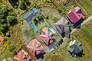 Aerial view of rural residential area with private homes between green fields