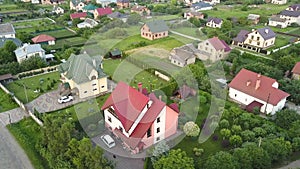 Aerial view of rural residential area with private homes between green fields.