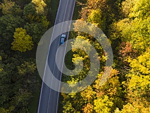 Aerial view of rural road with car in yellow and orange