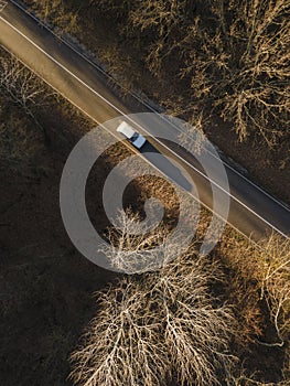 Aerial view of rural road with car in yellow and orange au