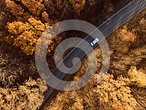 Aerial view of rural road with car in yellow and orange au