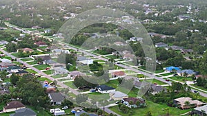 Aerial view of rural street traffic with driving cars in small town. American suburban landscape with private homes in