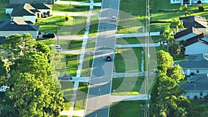 Aerial view of rural street traffic with driving cars in small town. American suburban landscape with private homes in