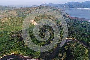 Aerial view of rural village with dam and river green forest