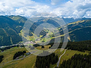 Aerial view from Saalbach to Hinterglemm and into the valley head of the Hinterglemm Mountains on a summer day in the photo