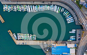 Aerial view of sail boats in marina port in harbor with blue turquoise seawater in urban city or town, Japan in travel trip and