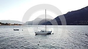 AERIAL VIEW. Sailboat docked in the bay - Lake Como at sunset - Travel destination