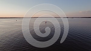 Aerial view of a sailboat on a lake at sunset