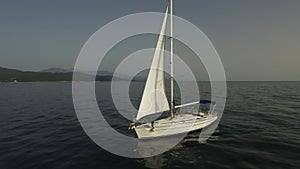 Aerial view of sailboat at sea. Footage. Sail Boat on Ocean aerial view. Beautiful aerial view of alone yacht sailing on