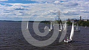 Aerial view of sailing yachts in a pond with rippled water surface. Video. Beautiful regattas floating on background of