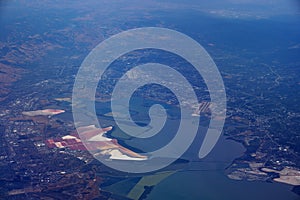 Aerial view of salt evaporation ponds, bridge, airports, cities