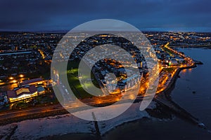 Aerial view on Salthill area of Galway city, Ireland. Night scene with illuminated roads, buildings and city lights and dark sky