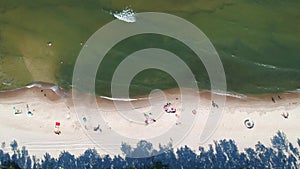 Aerial view on sand beach with sunbathers and sea waves