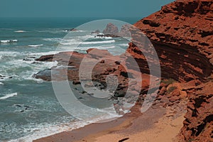 Aerial view of sandstone cliffs in Legzira Beach. Rugged coastline in Tiznit Province. Sea in Morocco, Africa. Atlantic Ocean.