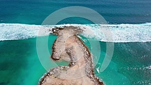 Aerial view of sandy beach with beautiful white waves, turquoise ocean water