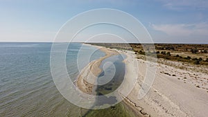 Aerial view of sandy beach and Black sea. Coastline with green bushes and grass. Dzharylhach island