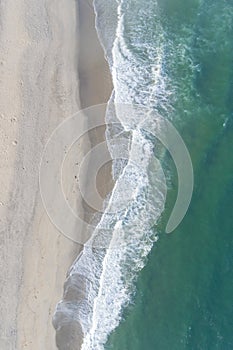 Aerial view of sandy beach and ocean with waves