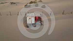 Aerial view sandy beach shack landscape. Camp bungalow on shore with dry grass