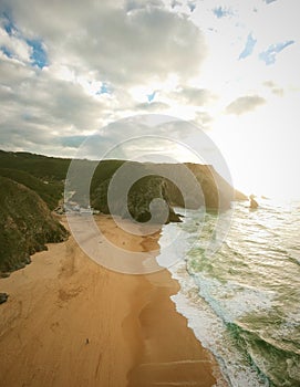 Aerial view from a sandy beach at the sunset with an amazing cliff